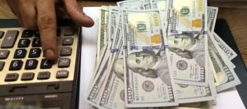 Dólar oscila, com alta nas projeções para inflação e PIB