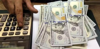 Dólar oscila, com alta nas projeções para inflação e PIB